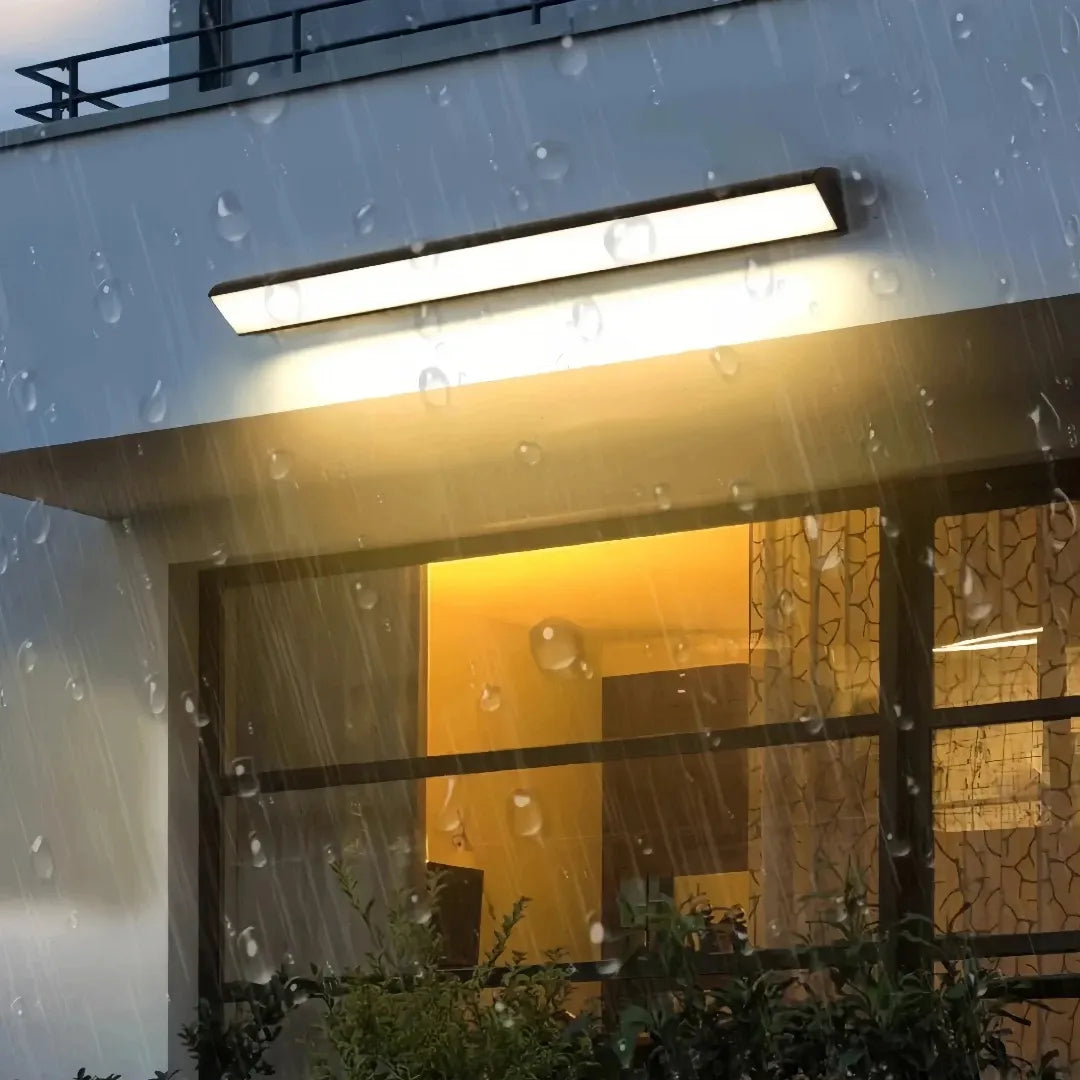Outdoor linear wall light above a planter beside a doorway