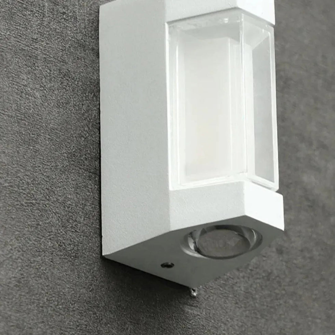 Close-up of the white wall light mounted on a textured exterior wall