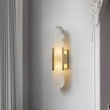 Gold oval marble LED wall light with soft warm illumination mounted on a bedroom wall