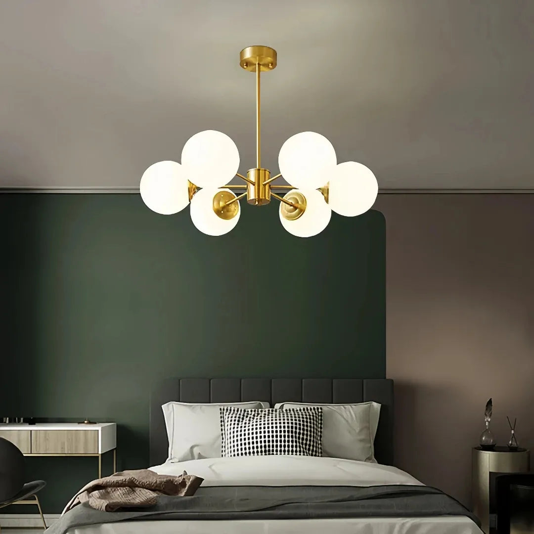 Gold 6-light chandelier with white glass globes in a bedroom