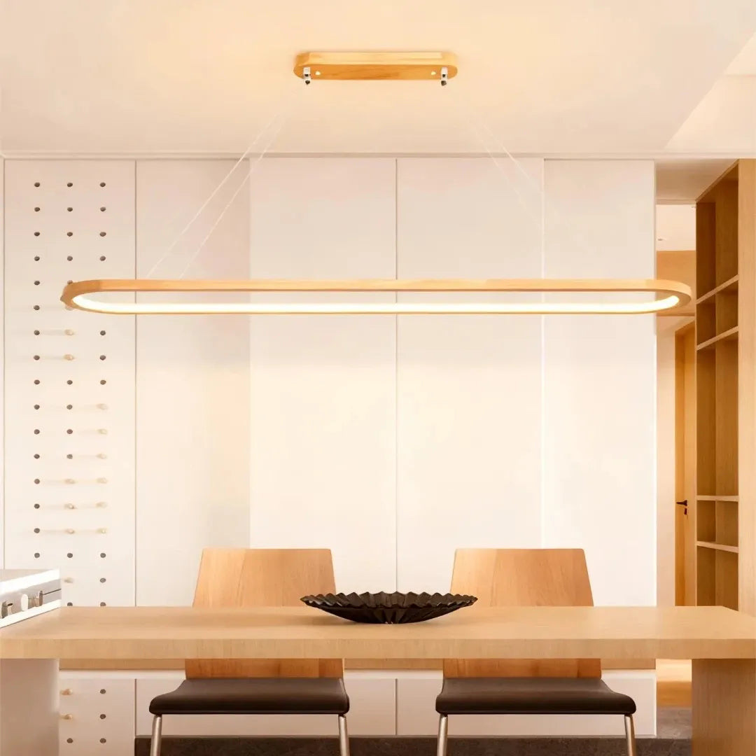 Oval wooden LED pendant light above a wooden dining table