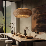 Woven rattan pendant light above a wooden dining table