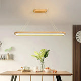 Light wood oval pendant above a dining table in an open-plan kitchen