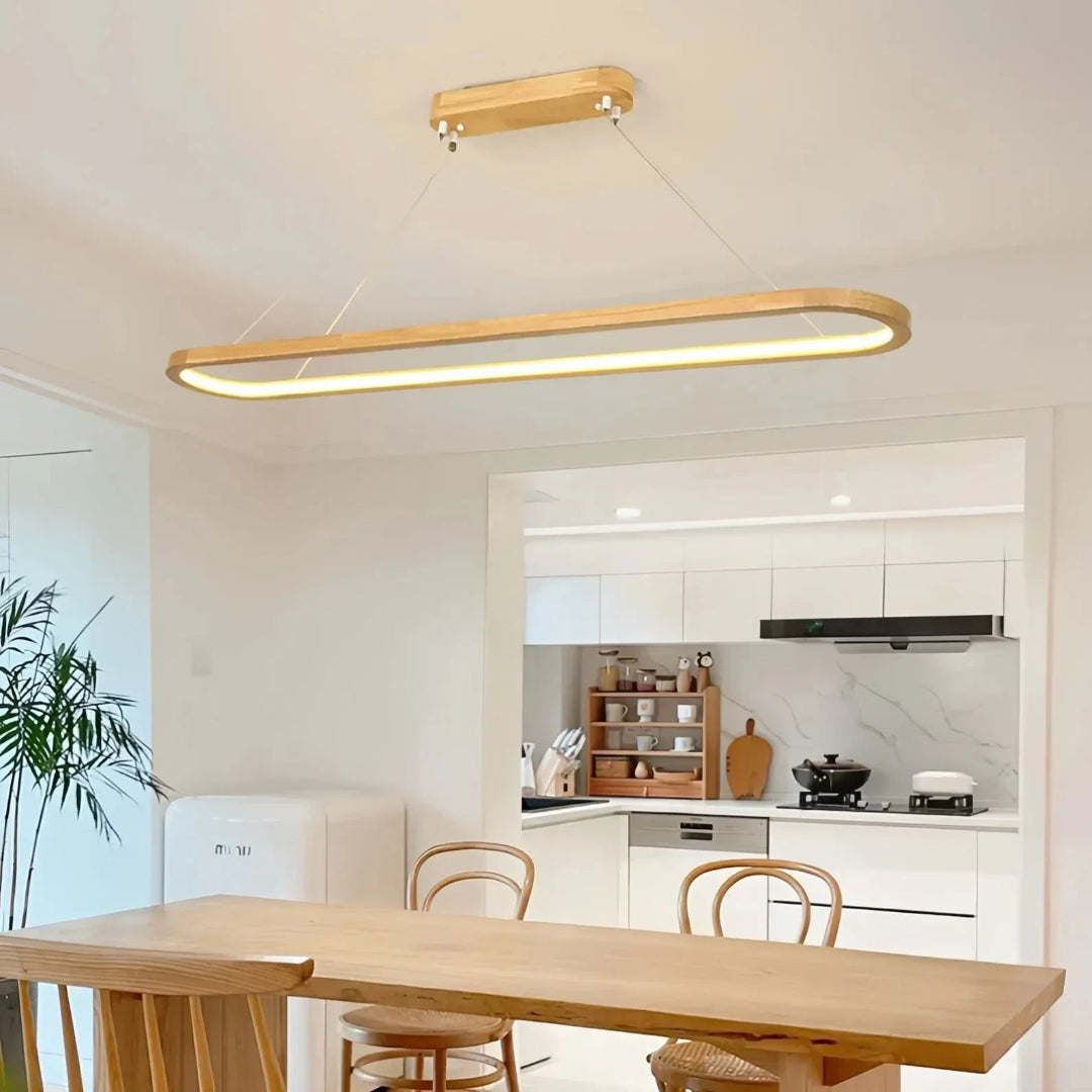 Oval wooden pendant above a dining table with cups and a vase