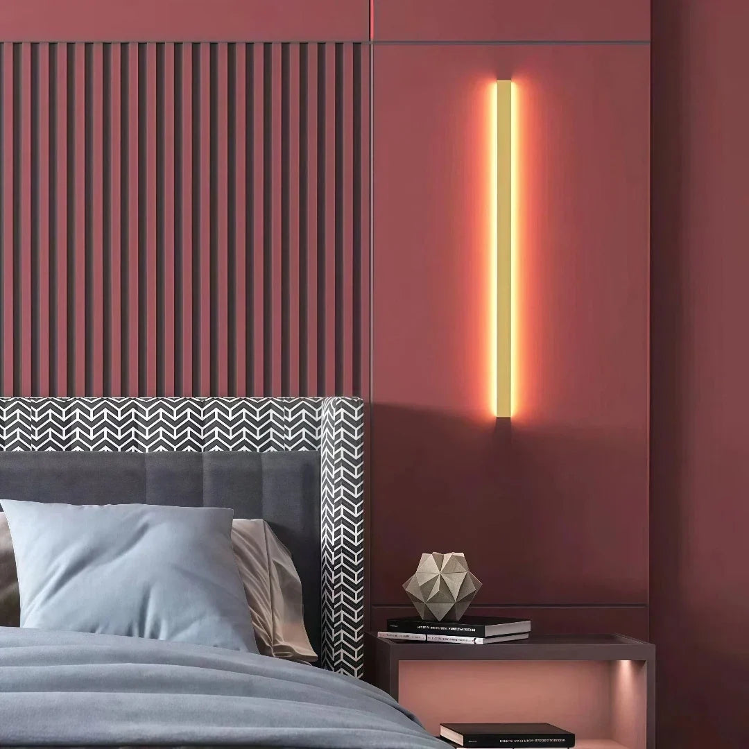 Gold linear LED wall light installed vertically beside a staircase