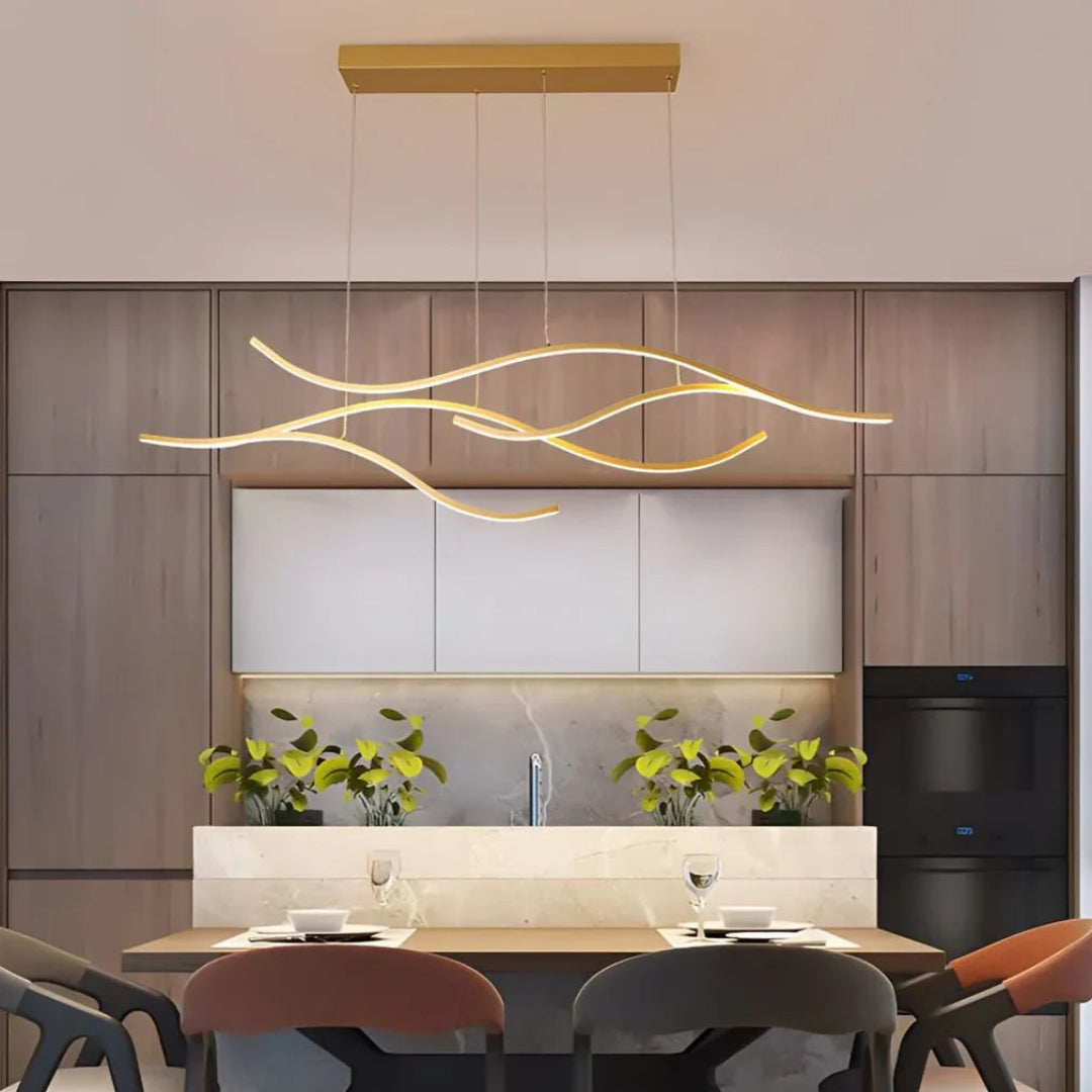 Gold wave LED pendant light above a dining table
